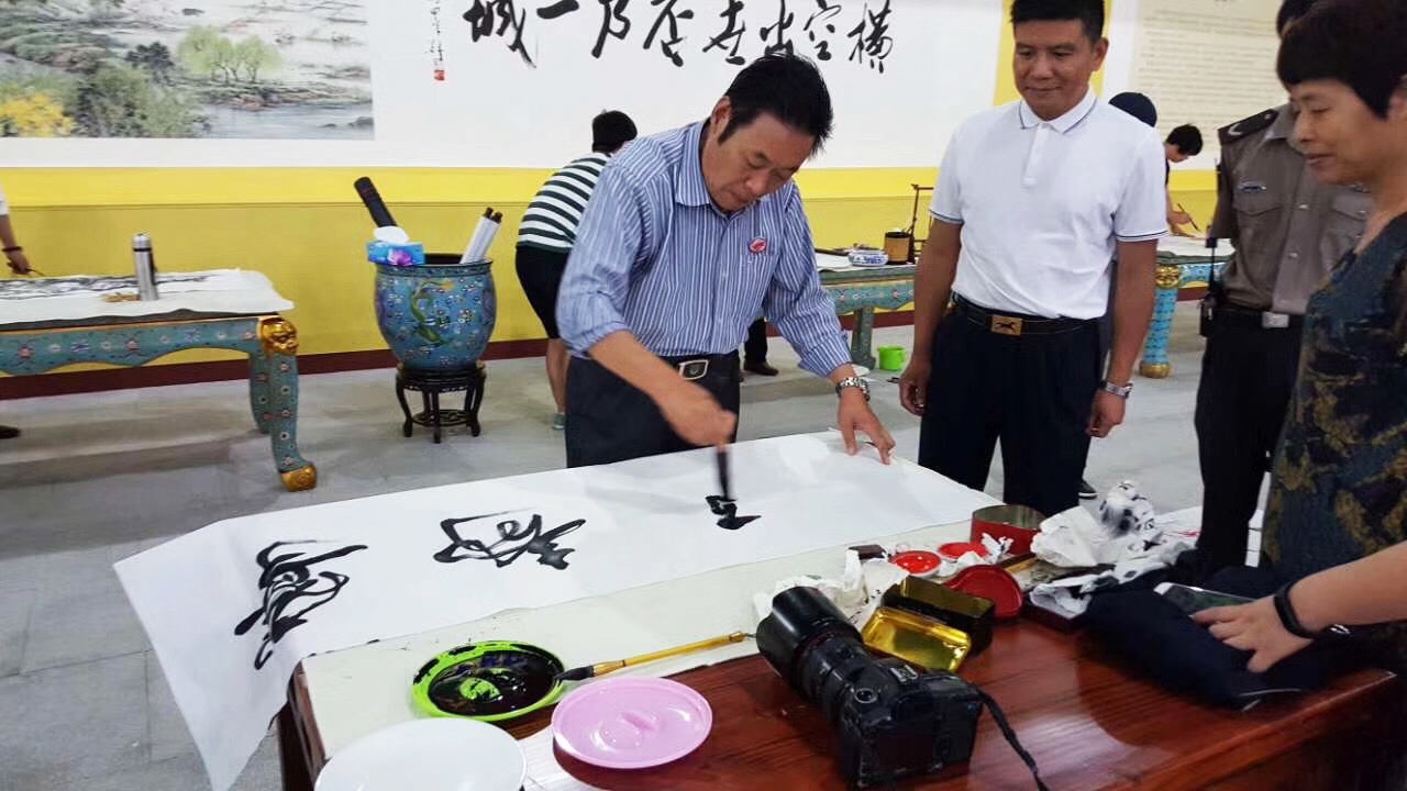 馮雪林在浙江橫店影視城現(xiàn)場(chǎng)創(chuàng)作寧?kù)o致遠(yuǎn)行書書法作品